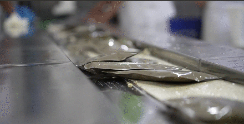 La Huerta de Oriente Meal Ready to Eat (MRE) packages on conveyor belt in a food processing facility